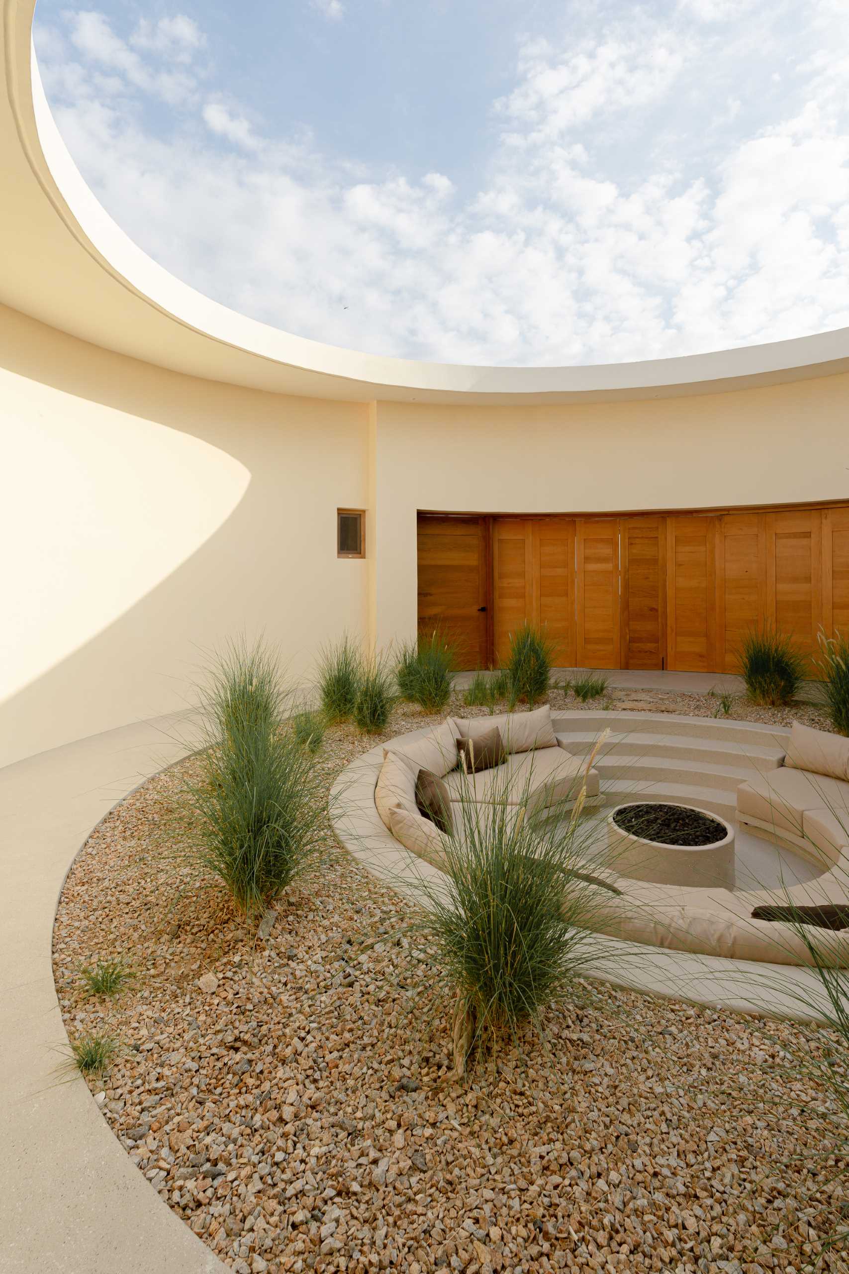 Surrounding the central patio of this contemporary house, the living spaces open fully from the entrance to the beach terrace, allowing for cross-ventilation and seamless integration between spaces.