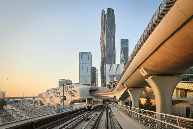 Futuristic cityscape with modern skyscrapers and a sleek automated train on elevated tracks, under clear skies.