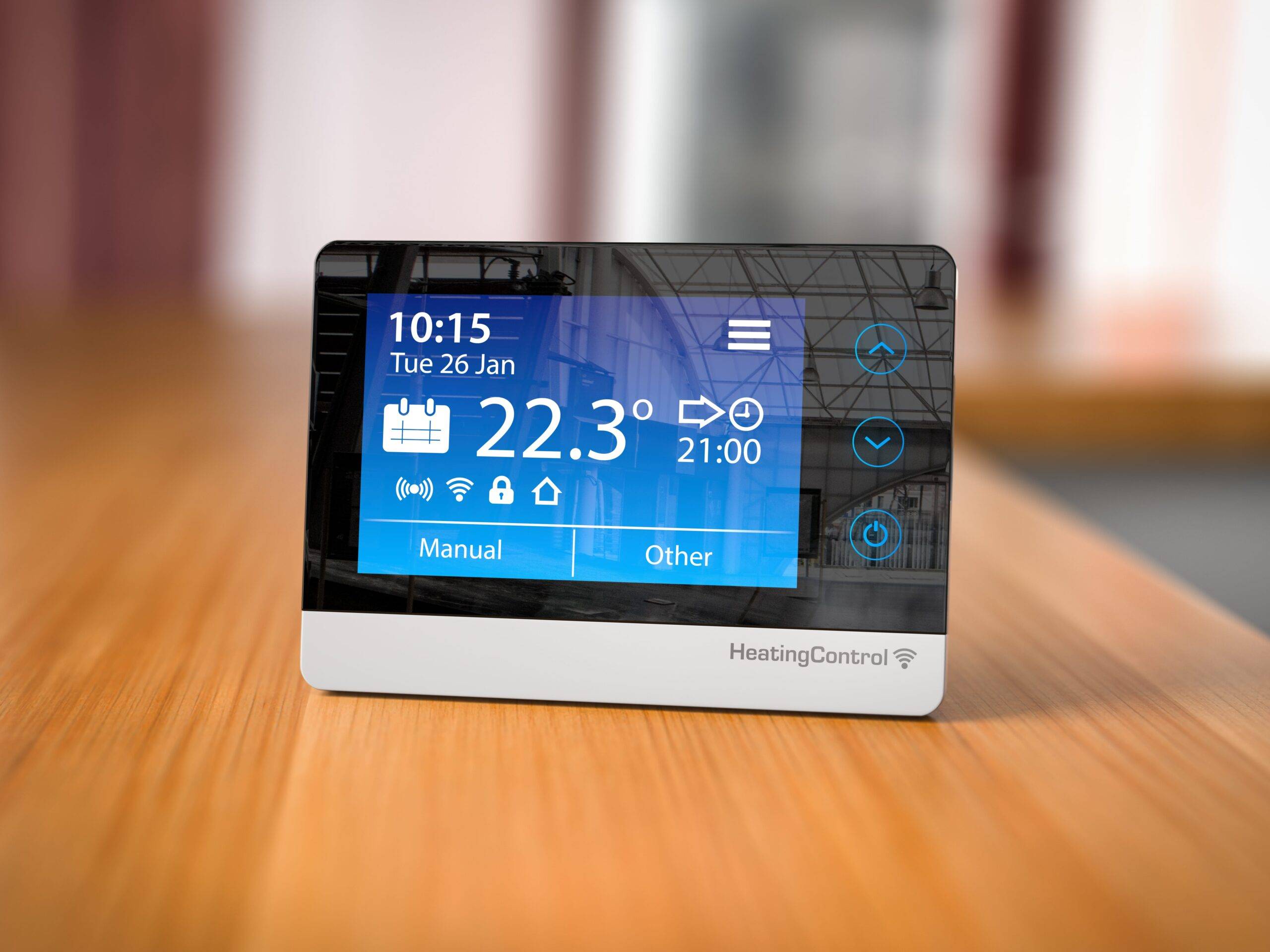 A smart digital thermostat sitting on a counter.