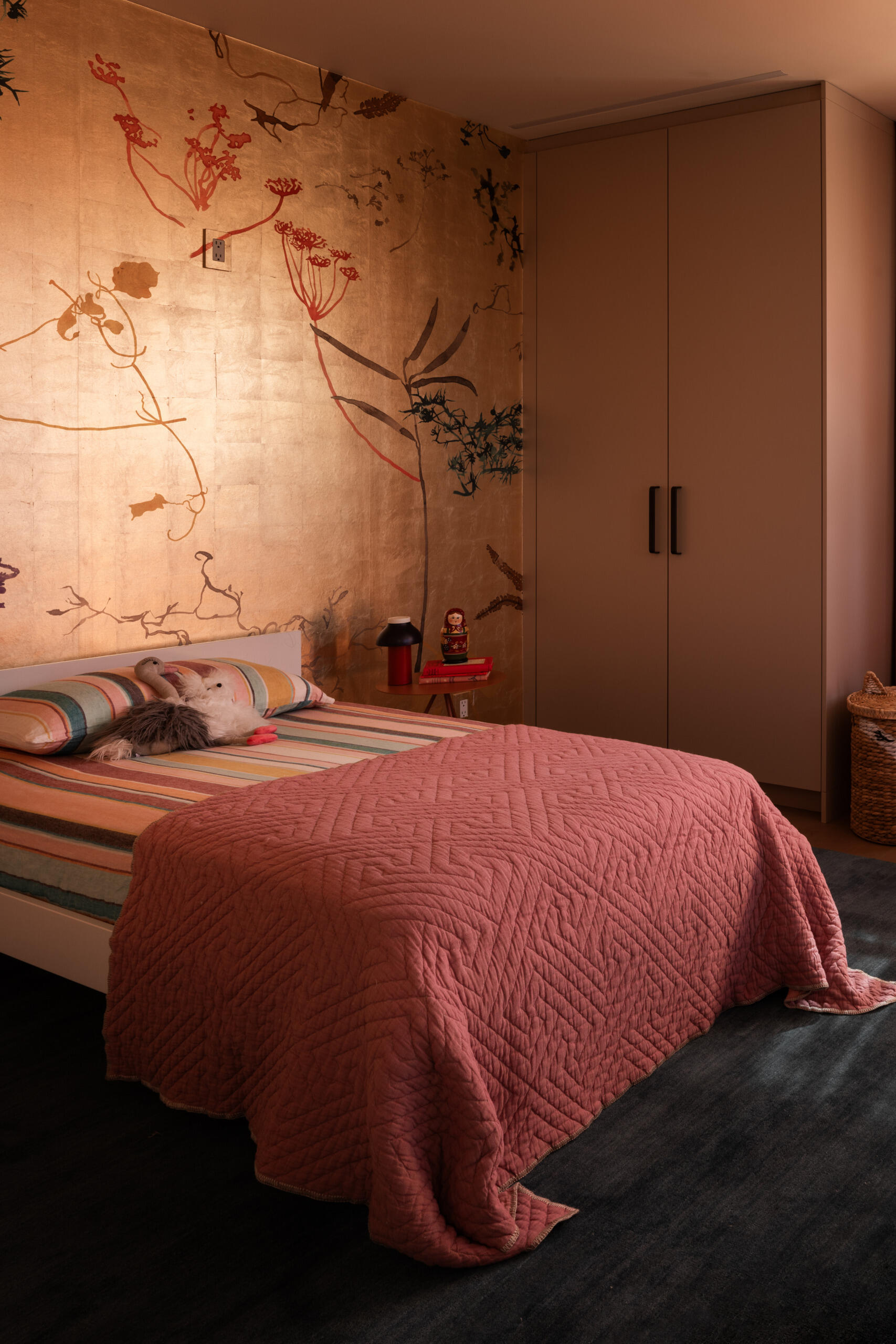 The kids’ bedroom strikes a balance between fun and finesse. A Calico wallcovering and Armadillo rug create a cozy, visually rich space that respects both play and rest.
