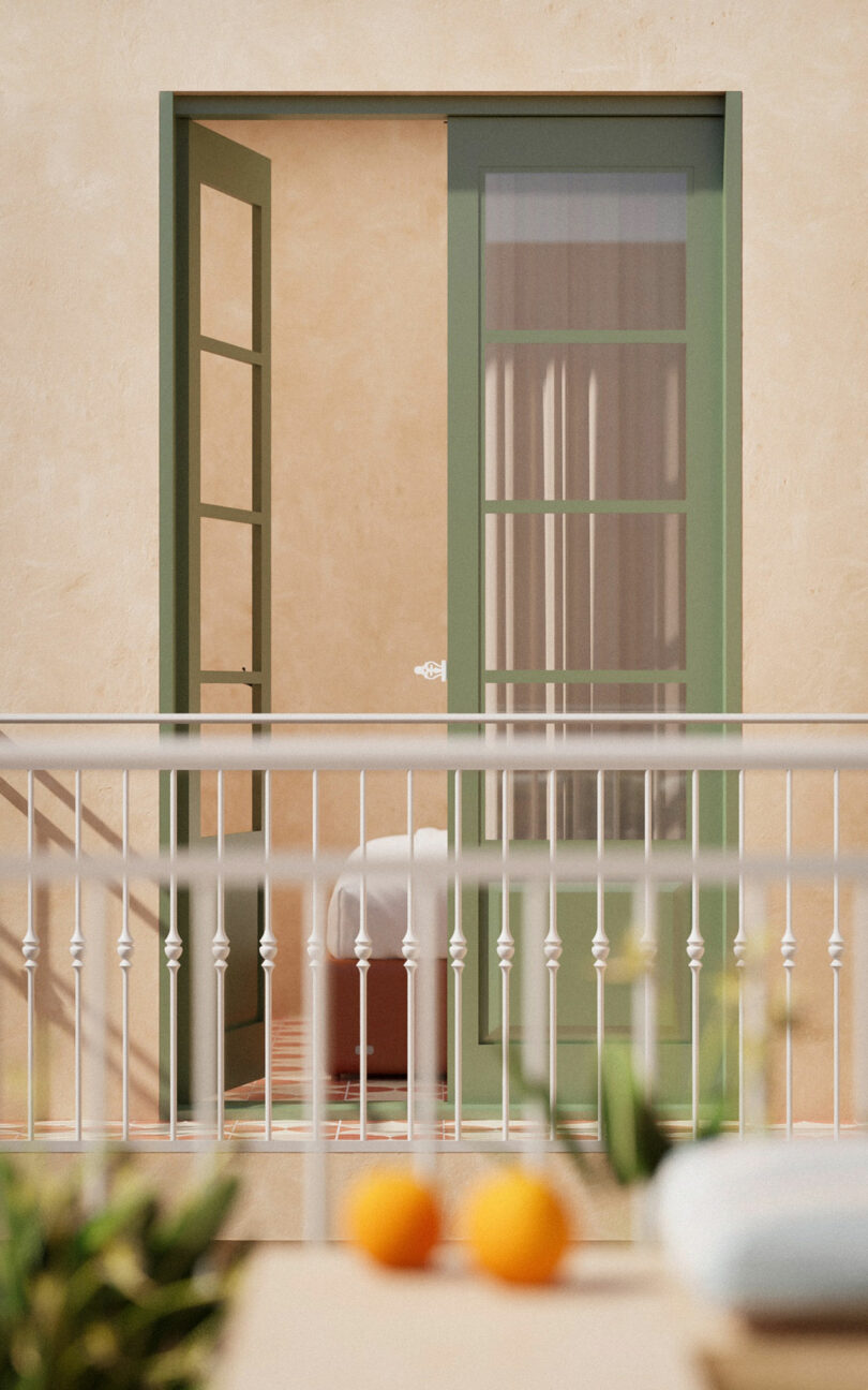 A green-framed glass door opens onto a balcony with a white railing; a round table with a white cloth is visible inside the room.