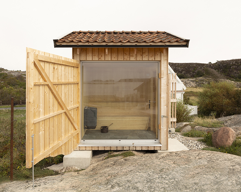 untreated wooden cladding wraps vernacular sauna sövall on sweden's rocky shoreline