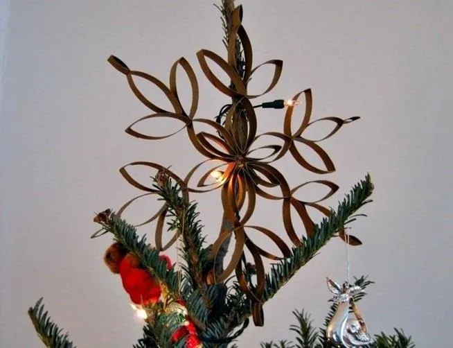 Christmas tree topper made from rolled paper in a floral design, adorned with lights.