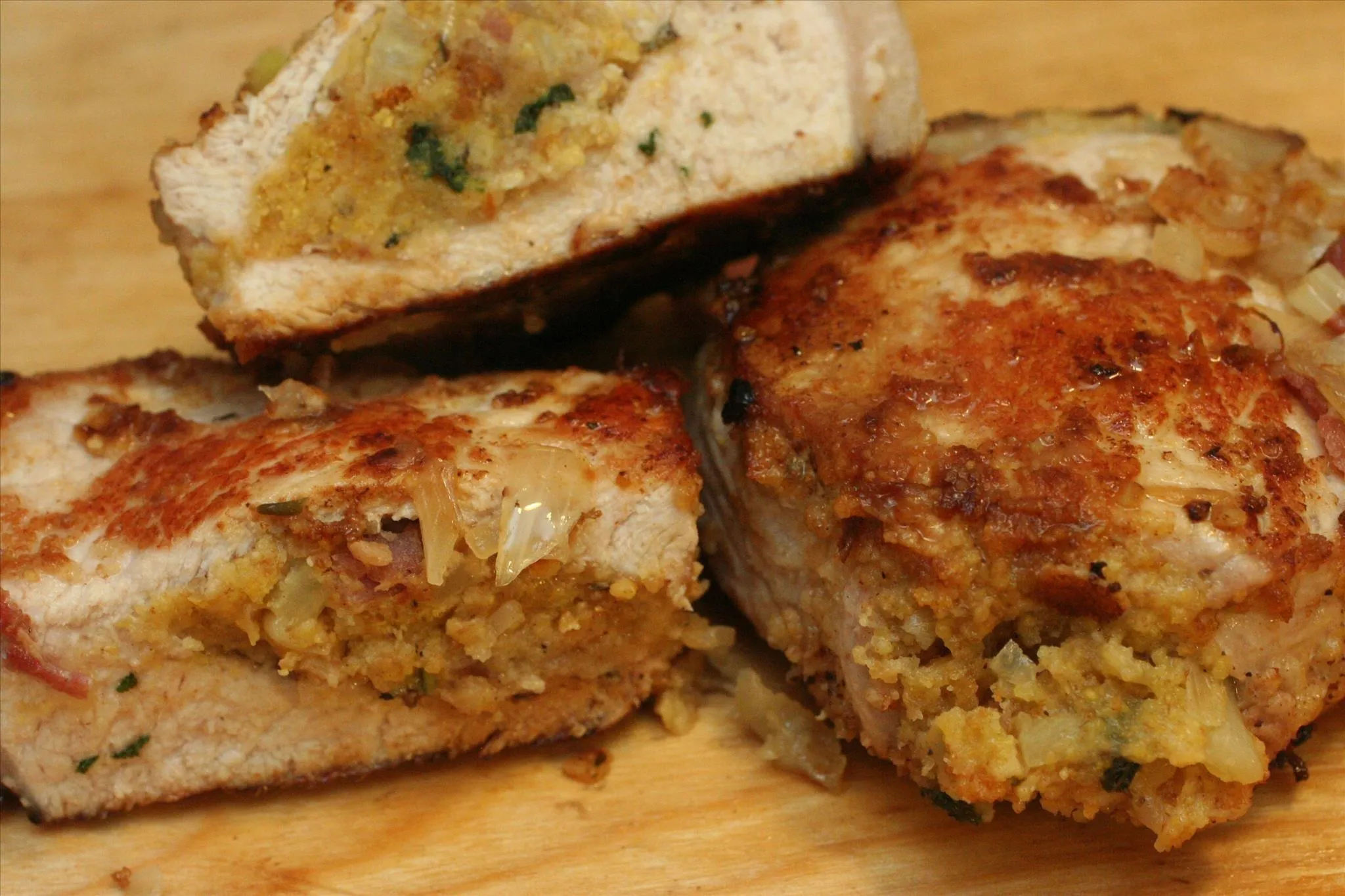Stuffed and fried chicken pieces on a wooden cutting board.
