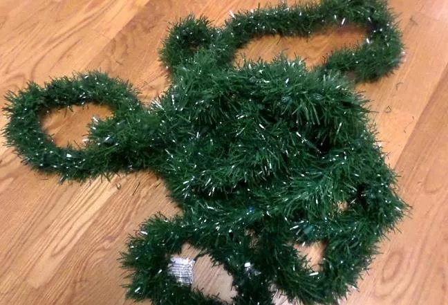 Green tinsel decoration on a wooden surface.