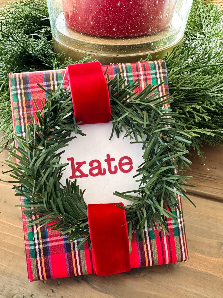 a Christmas garland tie shaped into a wreath as an accent on a gift wrapped present instead of using a bow.