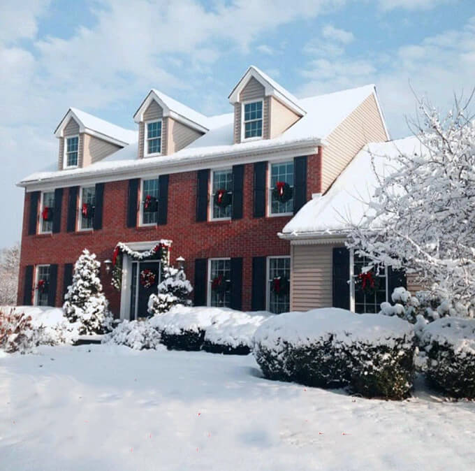 Outdoor Christmas decorating ideas using garland ties to hang garland and wreaths on a homes exterior.
