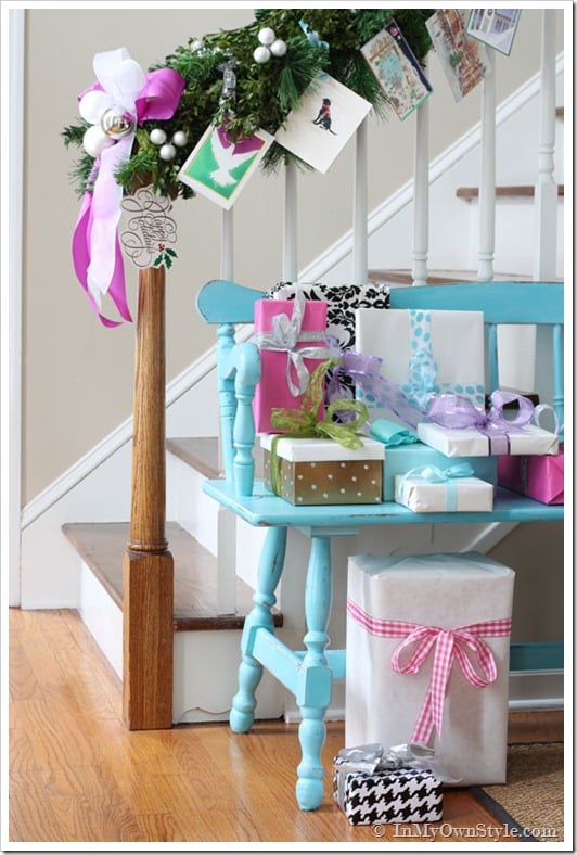 Christmas cards tied on staircase garland using ribbon and garland ties.
