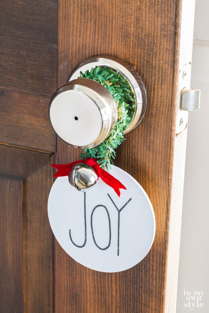 Wooden joy ornament hanging on doorknob.