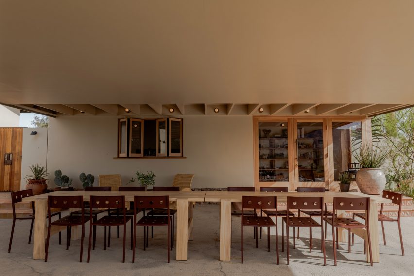 A covered outdoor dining area with large wooden tables