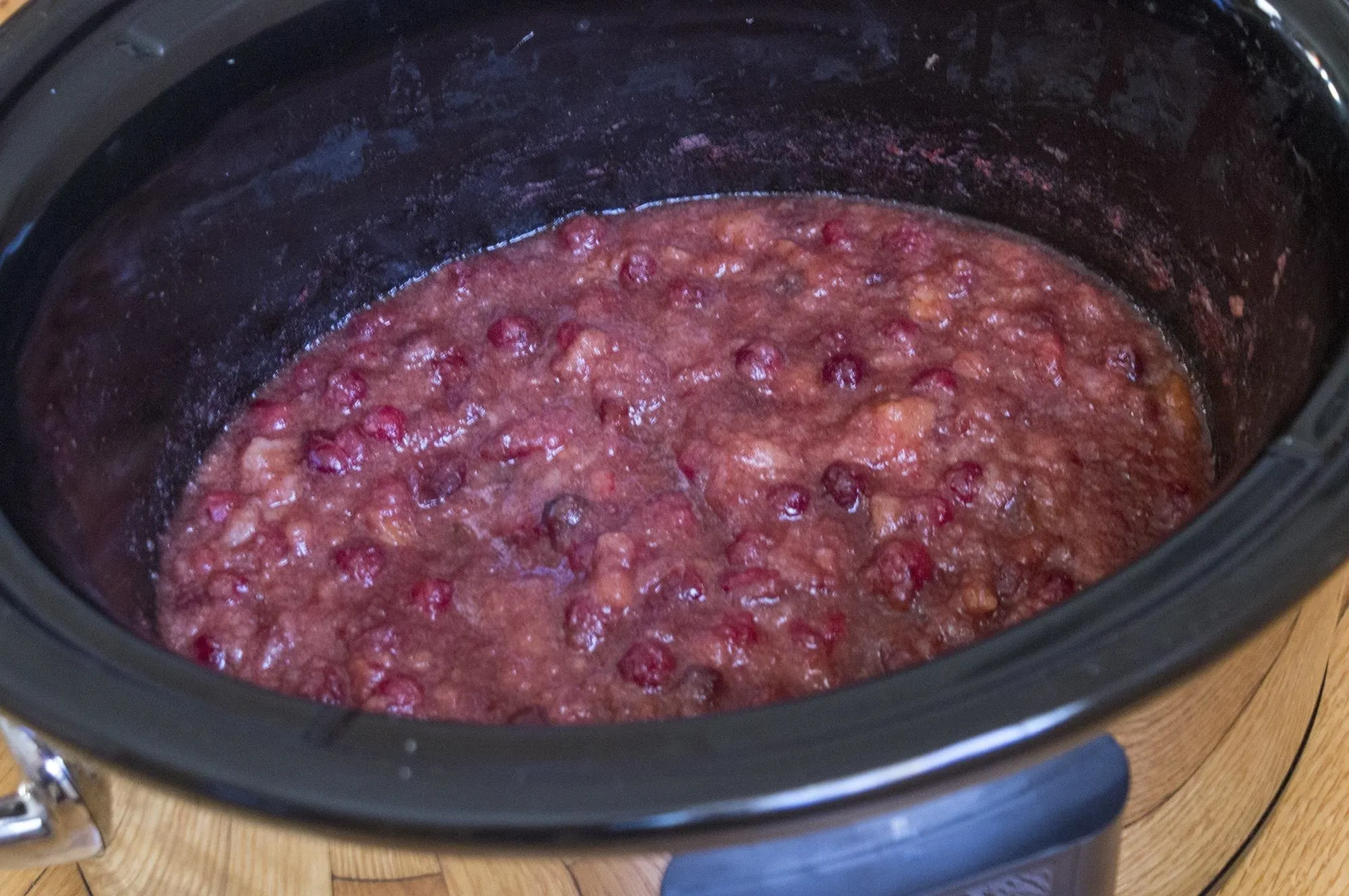 Slow cooker filled with red fruit compote.